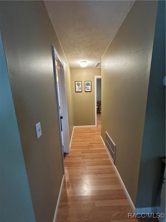 18 56th St, Yankeetown, FL 34498 - hall featuring a textured ceiling and light wood-style floors