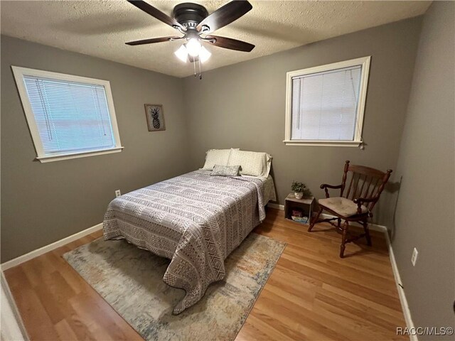 18 56th St, Yankeetown, FL 34498 - bedroom featuring light wood-type flooring, a textured ceiling, and ceiling fan