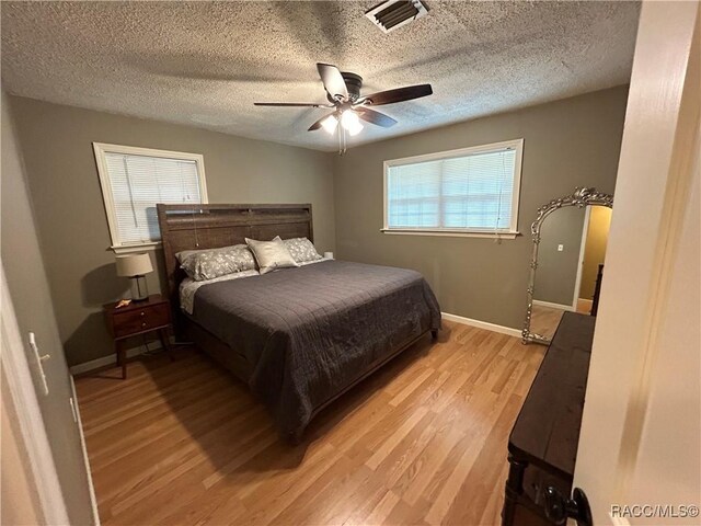 18 56th St, Yankeetown, FL 34498 - bedroom with light wood finished floors, ceiling fan, and a textured ceiling
