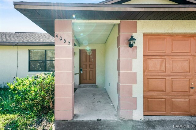 single story home featuring an attached garage, cooling unit, concrete driveway, stucco siding, and a front yard