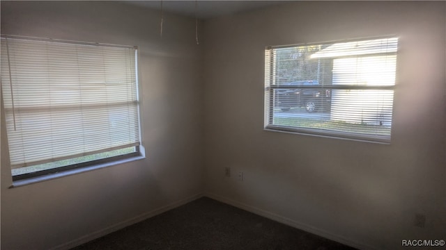 unfurnished room featuring plenty of natural light and baseboards