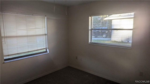 spare room featuring plenty of natural light and baseboards