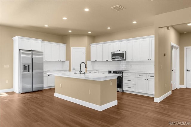 kitchen with white cabinetry, stainless steel appliances, and a center island with sink