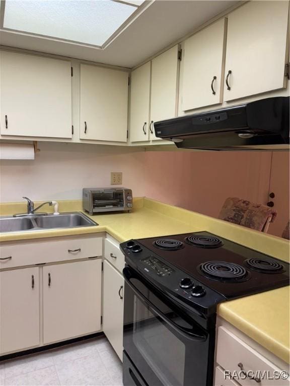 kitchen featuring white cabinetry, black electric range oven, and sink