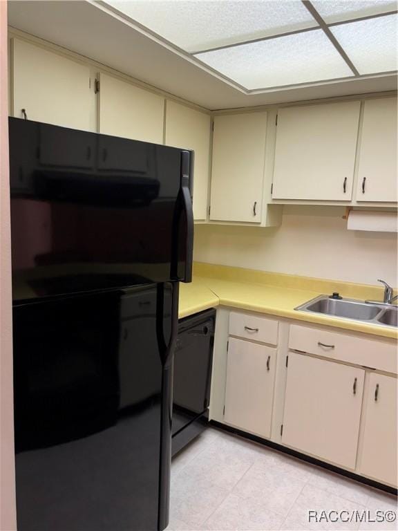 kitchen featuring sink, cream cabinets, and black appliances