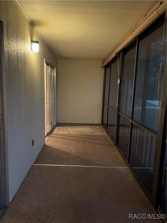 hallway featuring crown molding and carpet flooring