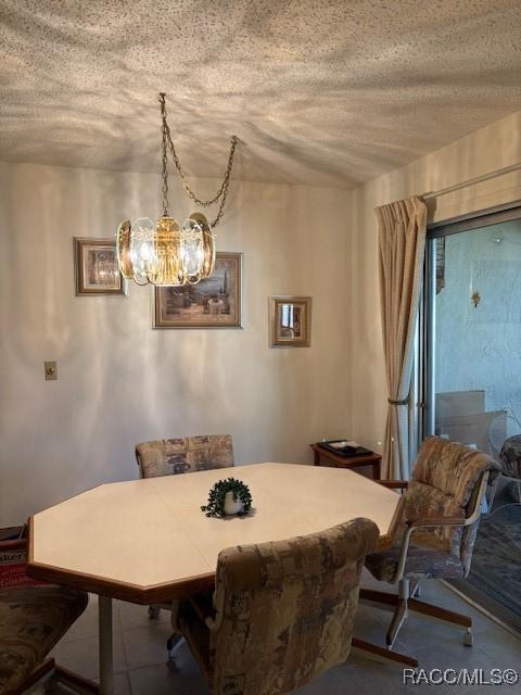 dining room featuring a chandelier and a textured ceiling