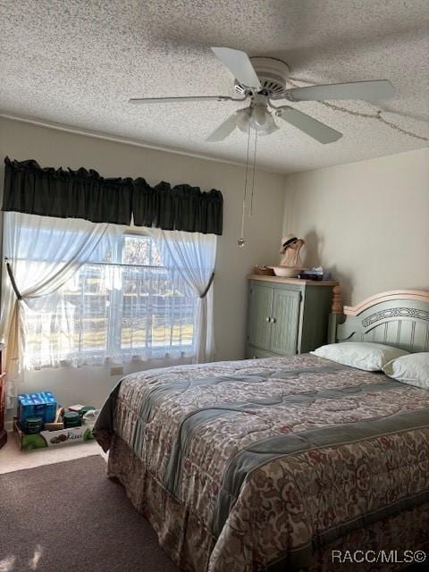 bedroom featuring ceiling fan, carpet, and a textured ceiling