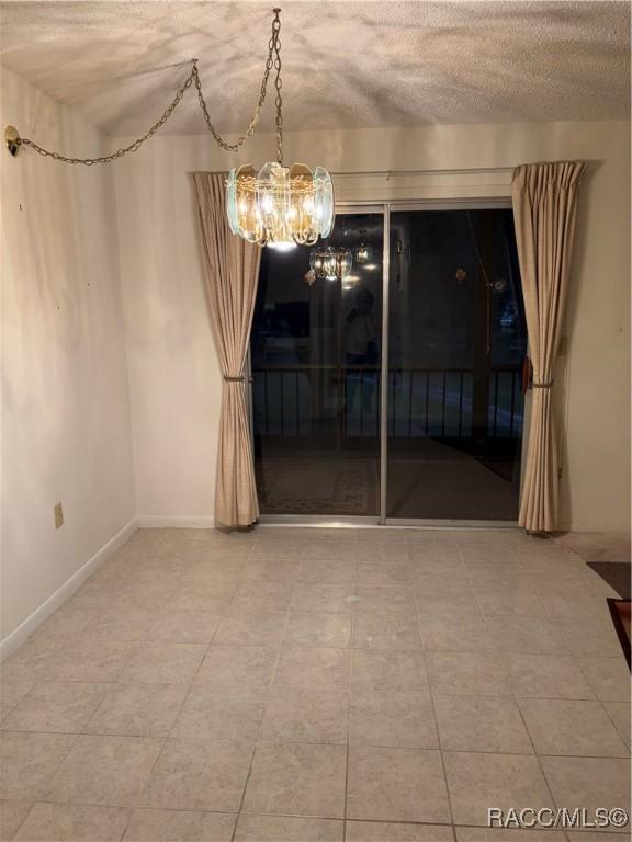 unfurnished dining area with a textured ceiling