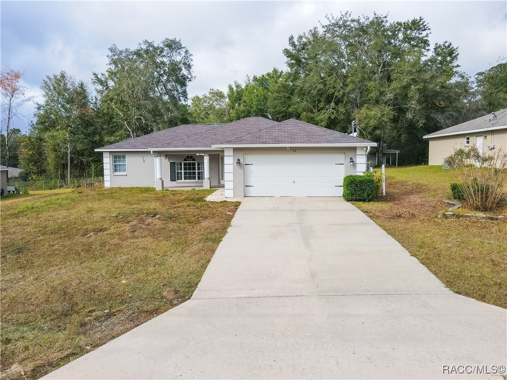 single story home featuring a garage and a front lawn