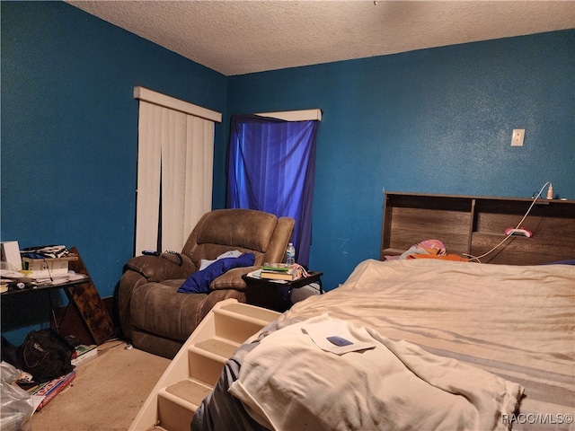 bedroom with a textured ceiling and carpet floors