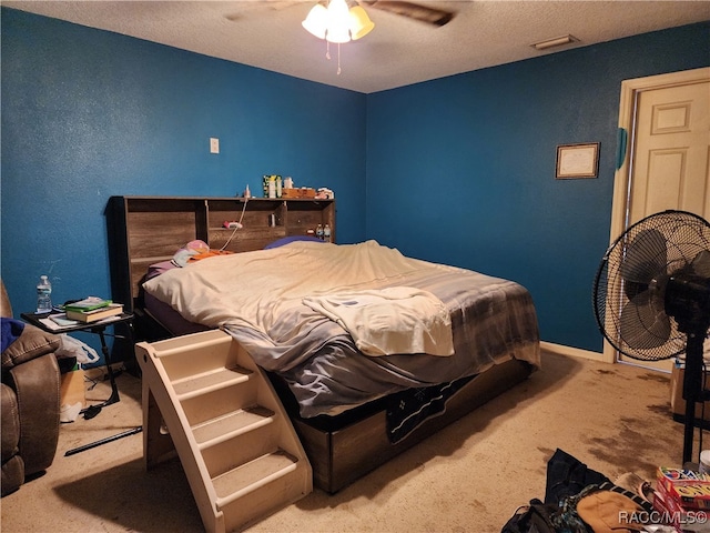 bedroom featuring ceiling fan, carpet floors, and a textured ceiling