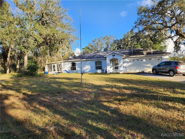 ranch-style home with a garage and a front yard