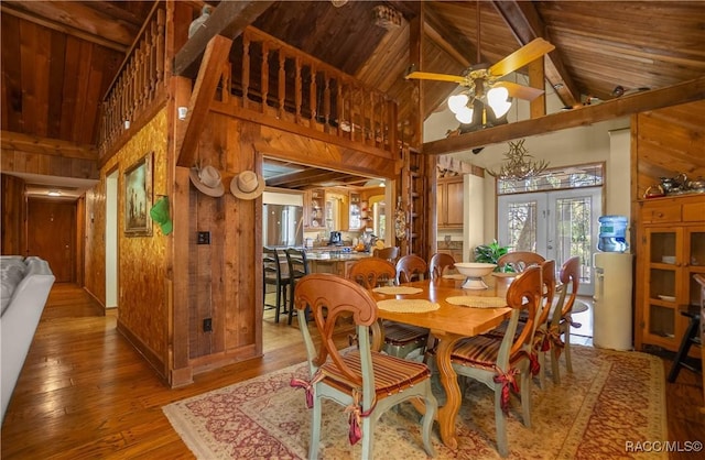 dining room featuring wooden ceiling, wooden walls, and wood finished floors