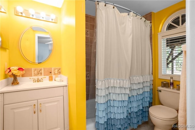 full bathroom featuring shower / bathtub combination with curtain, vanity, and toilet