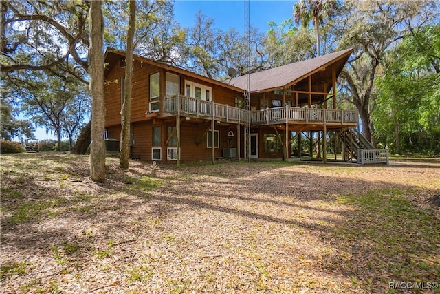 rear view of property featuring stairway, central AC unit, and a deck