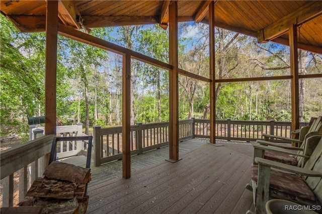 unfurnished sunroom featuring wood ceiling and vaulted ceiling with beams