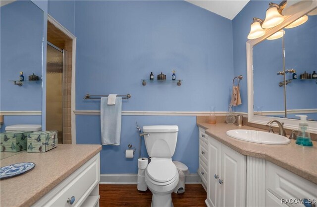 full bath featuring toilet, wood finished floors, vanity, baseboards, and an enclosed shower