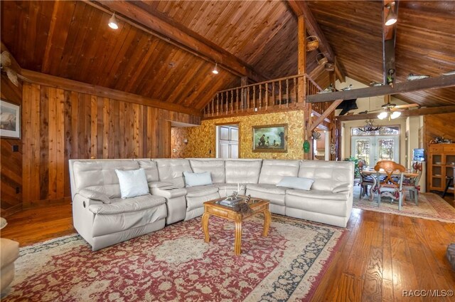 living room featuring beam ceiling, wooden ceiling, hardwood / wood-style flooring, and wooden walls