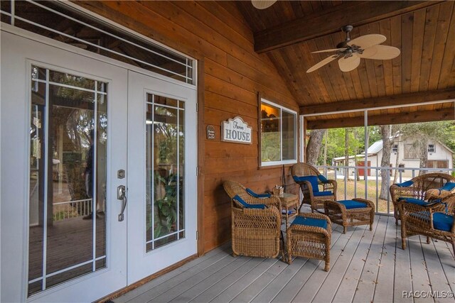 sunroom featuring lofted ceiling with beams, french doors, wooden ceiling, and a ceiling fan