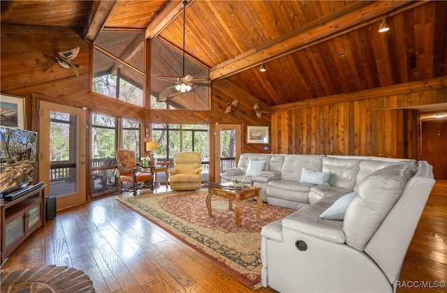 living room with beamed ceiling, wood walls, wooden ceiling, and hardwood / wood-style flooring