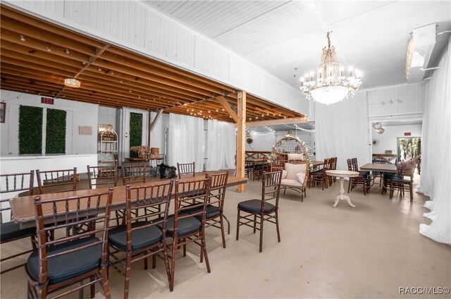 dining area featuring an inviting chandelier and concrete flooring