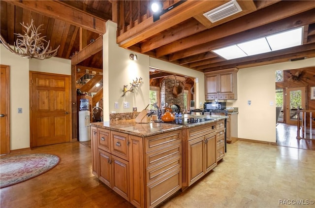 kitchen with a wealth of natural light, visible vents, beamed ceiling, and black appliances