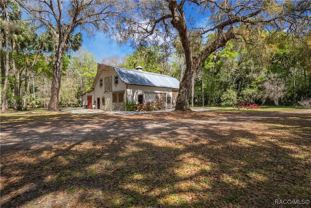 view of side of property featuring metal roof and a gambrel roof