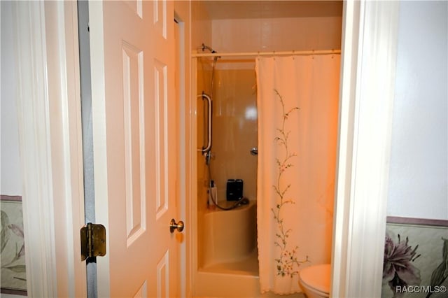 bathroom with curtained shower and toilet