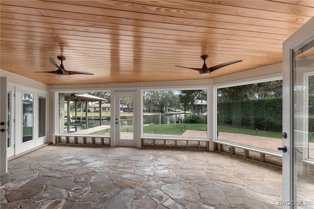 unfurnished sunroom with a healthy amount of sunlight, a water view, and wood ceiling