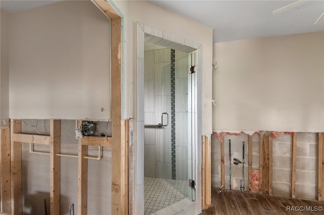 bathroom with hardwood / wood-style flooring, an enclosed shower, and ceiling fan