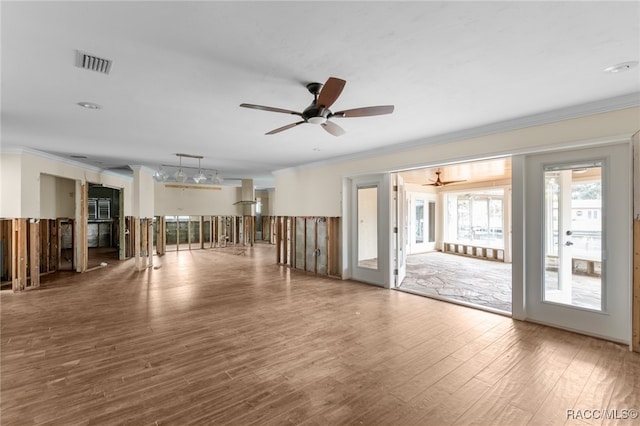 empty room featuring ceiling fan, wood-type flooring, ornamental molding, and french doors