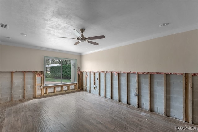 spare room featuring hardwood / wood-style floors, ceiling fan, and crown molding