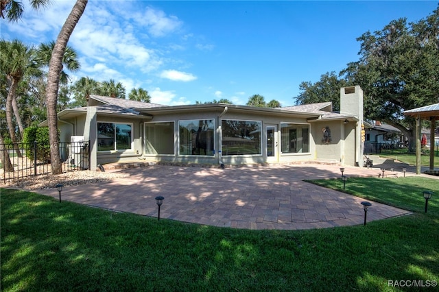 back of property with a patio area and a lawn