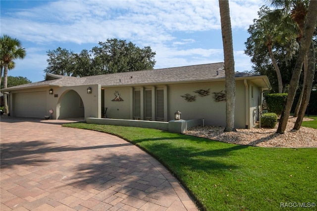 single story home featuring a garage and a front lawn