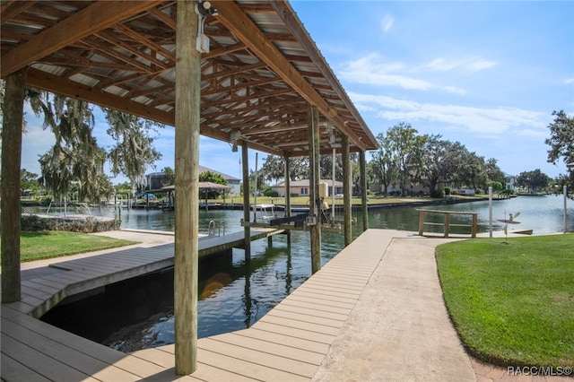 dock area with a lawn and a water view