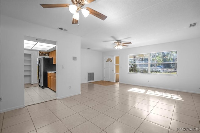 unfurnished living room with light tile patterned floors and ceiling fan