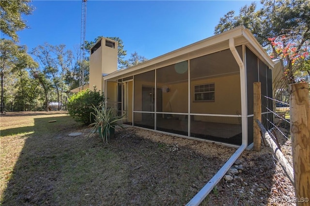 rear view of house featuring a sunroom