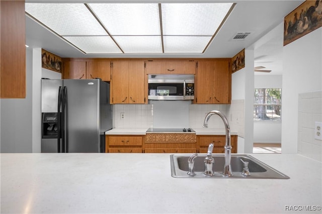 kitchen with appliances with stainless steel finishes, sink, and backsplash