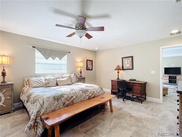 bedroom with a textured ceiling and ceiling fan