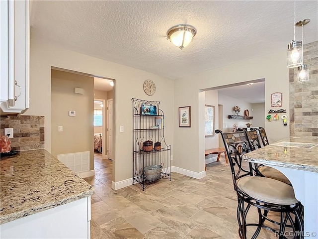 dining area with a textured ceiling and a wealth of natural light