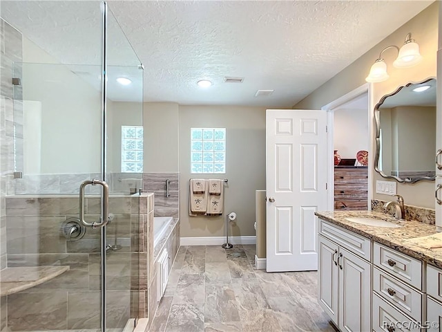 bathroom featuring vanity, a textured ceiling, and shower with separate bathtub