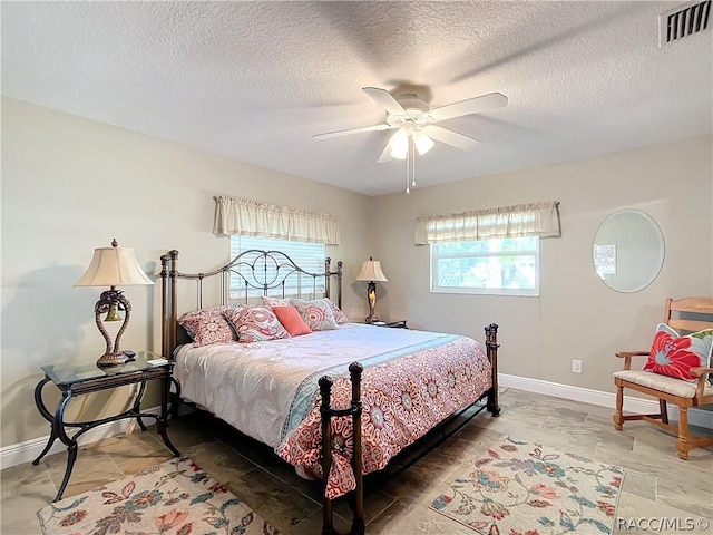 bedroom with ceiling fan and a textured ceiling