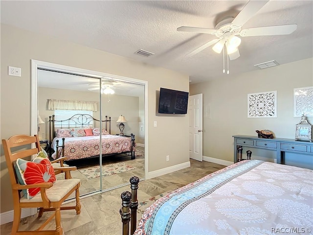 bedroom featuring ceiling fan, a closet, and a textured ceiling