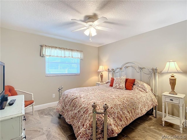 bedroom with ceiling fan and a textured ceiling