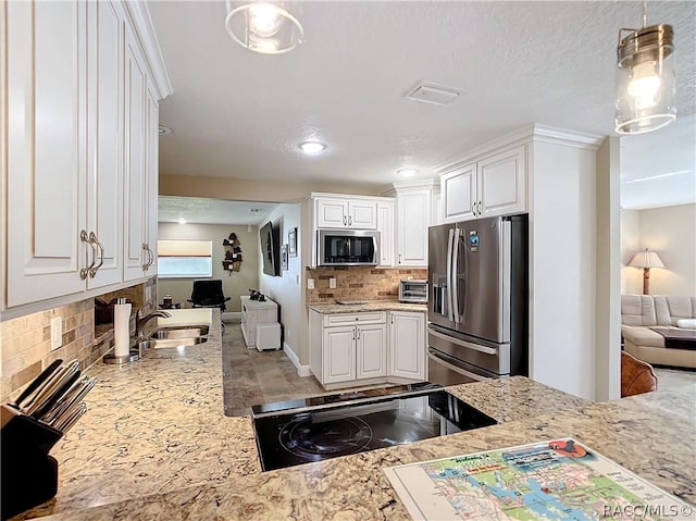 kitchen with white cabinets, appliances with stainless steel finishes, and decorative light fixtures