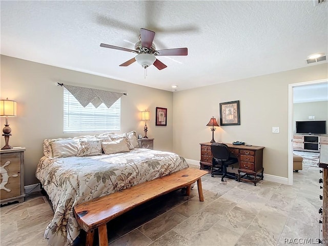 bedroom with ceiling fan and a textured ceiling