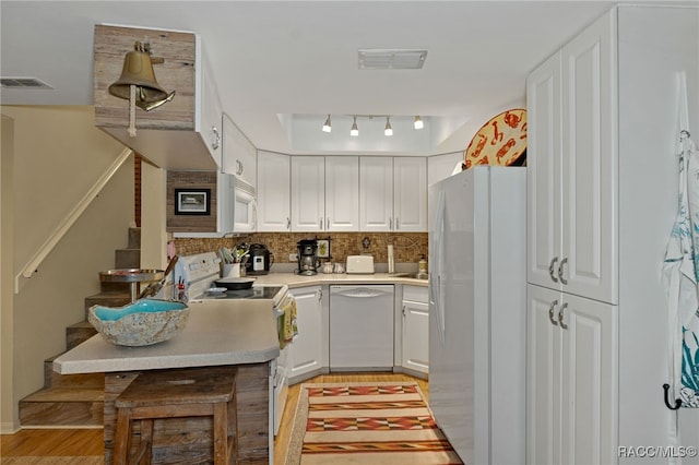 kitchen with decorative backsplash, light wood-type flooring, track lighting, white appliances, and white cabinets