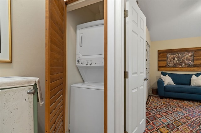 clothes washing area featuring stacked washing maching and dryer