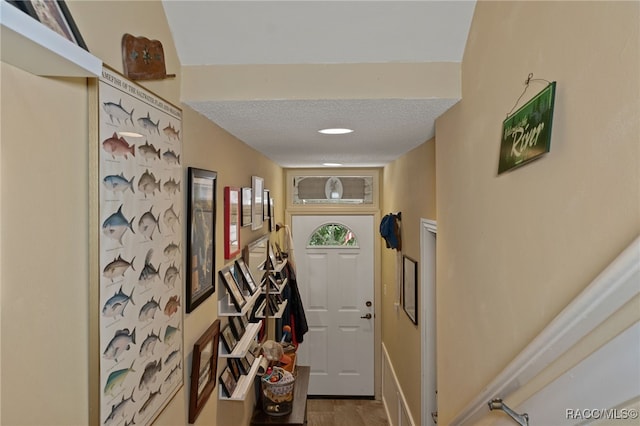 doorway to outside featuring a textured ceiling